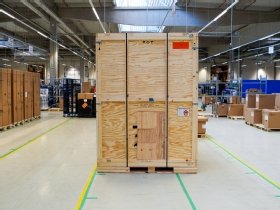 Photographie du conditionnement dans un coffre de bois d'une baie de serveurs refroidis à l'eau.